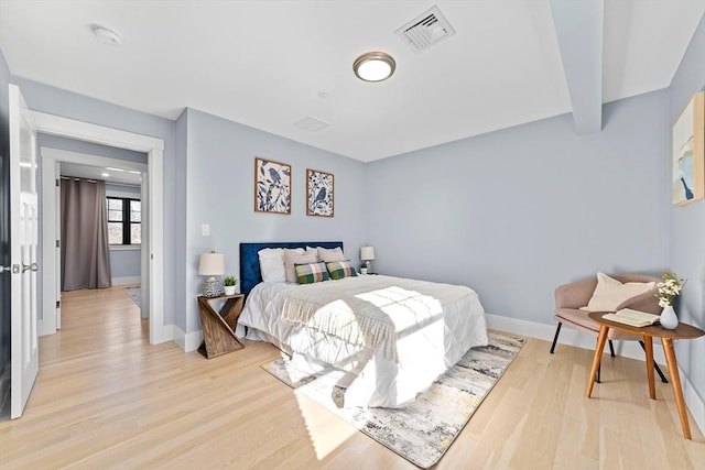 bedroom featuring light wood-type flooring, baseboards, and visible vents