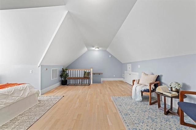 interior space featuring lofted ceiling, visible vents, baseboards, and wood finished floors