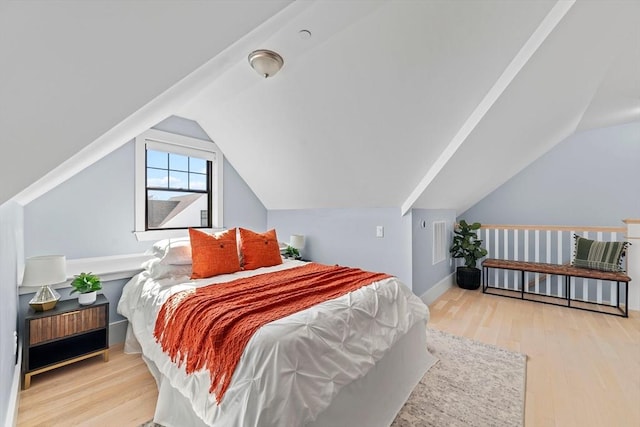 bedroom with lofted ceiling, wood finished floors, and visible vents