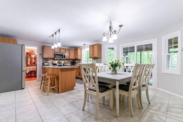 dining room featuring light tile patterned floors, a chandelier, and baseboards