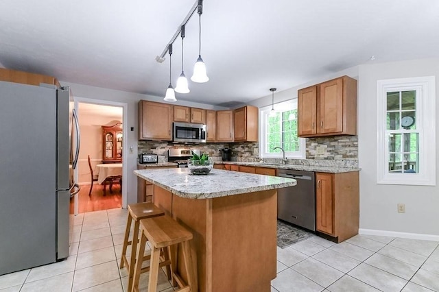 kitchen featuring appliances with stainless steel finishes, light tile patterned floors, and decorative backsplash