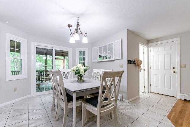 dining room featuring light tile patterned flooring, baseboards, and a chandelier