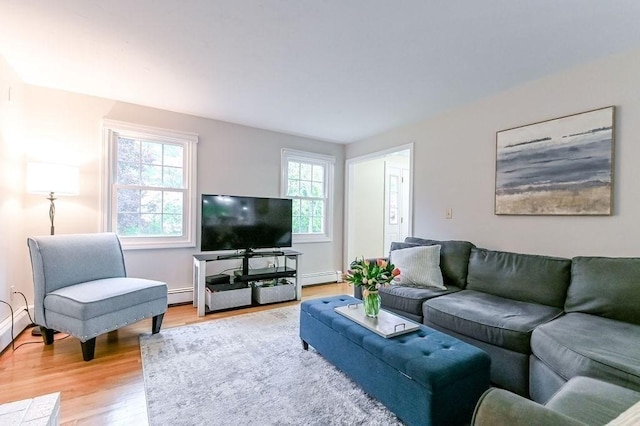living area featuring light wood-style floors, baseboard heating, and baseboards
