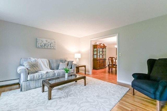 living area featuring a baseboard radiator, wood finished floors, and baseboards