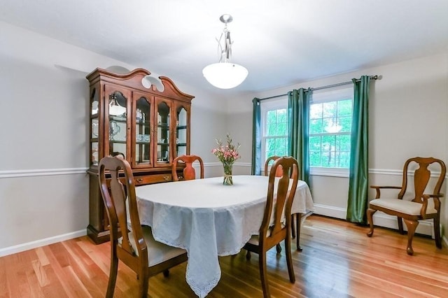 dining area featuring light wood-type flooring and baseboards