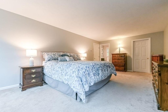 bedroom with light carpet and baseboards