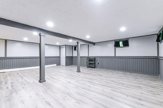 finished below grade area featuring wood finished floors, wainscoting, and recessed lighting