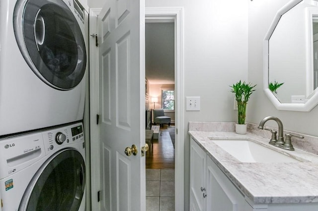washroom featuring stacked washer / dryer and light tile patterned floors