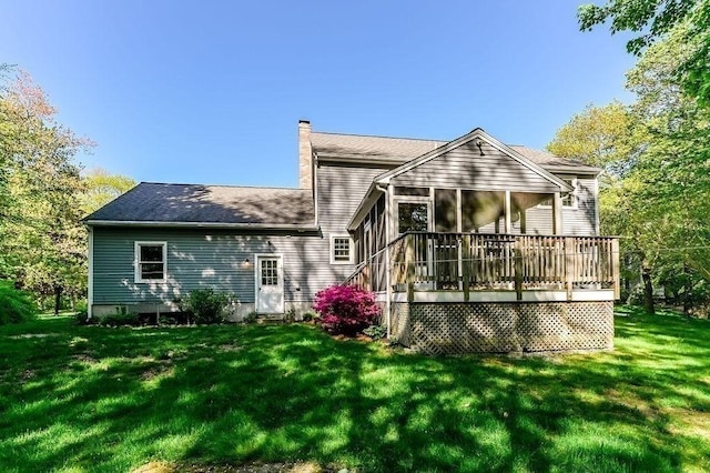 back of house with a chimney, a yard, and a sunroom