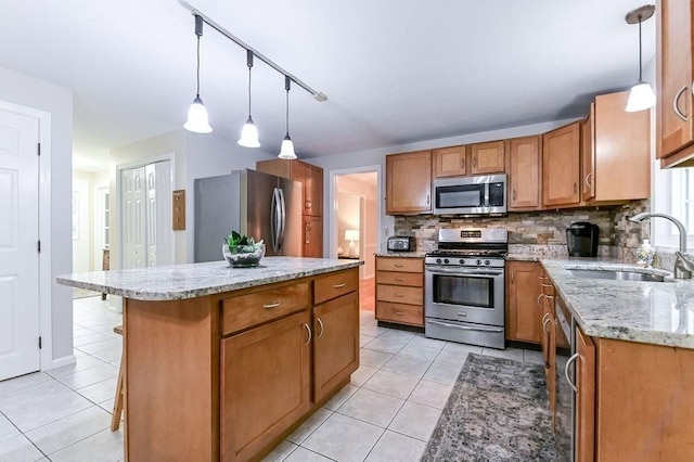 kitchen with appliances with stainless steel finishes, a sink, light tile patterned floors, and backsplash