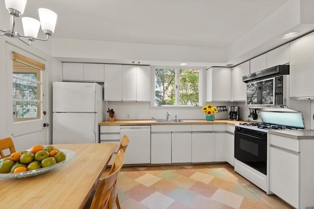 kitchen with plenty of natural light, a sink, light floors, and white appliances