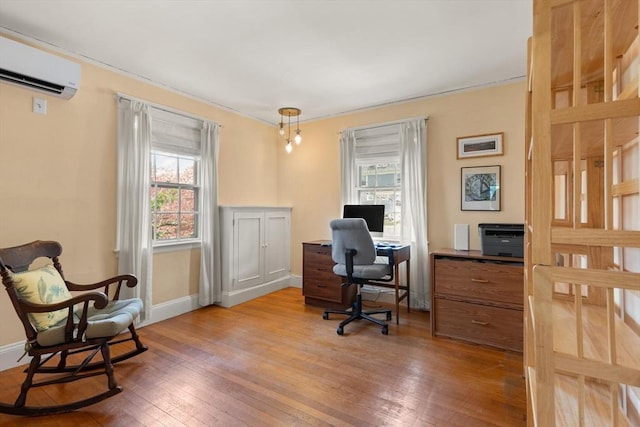 office space with wood-type flooring, an AC wall unit, and baseboards