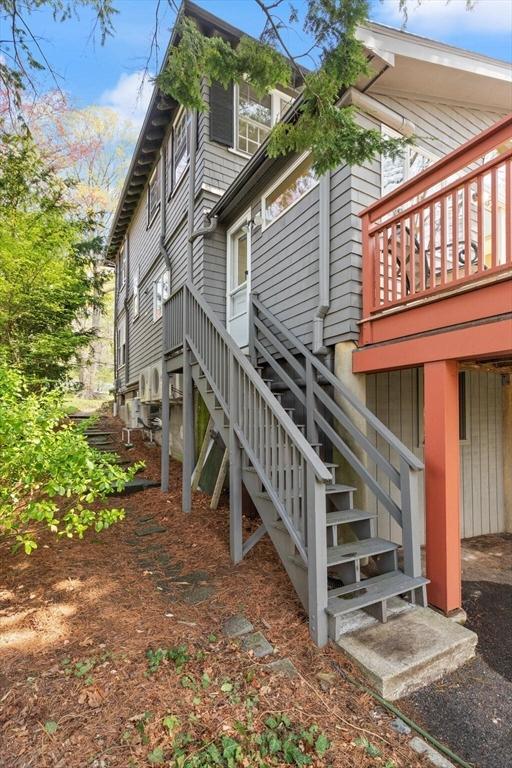 view of side of home featuring stairs and a wooden deck