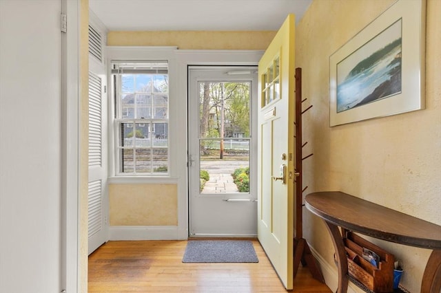entryway with baseboards and light wood finished floors