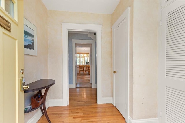 hall featuring baseboards and light wood-type flooring
