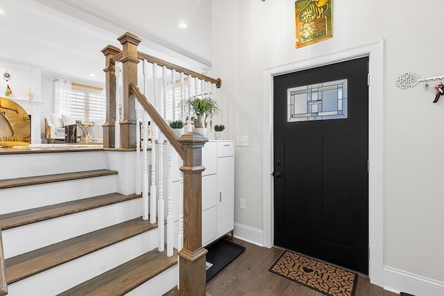 foyer entrance featuring dark wood finished floors, stairway, recessed lighting, and baseboards