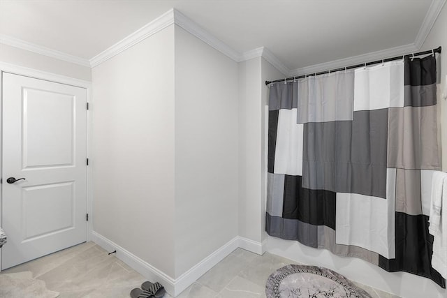 bathroom with curtained shower, crown molding, and baseboards