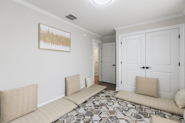 bedroom with a closet, visible vents, crown molding, and baseboards