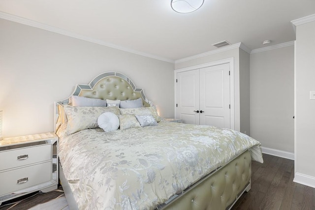 bedroom with visible vents, dark wood-type flooring, baseboards, ornamental molding, and a closet