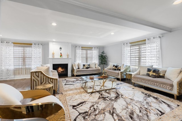 living area with a glass covered fireplace, recessed lighting, crown molding, and wood finished floors