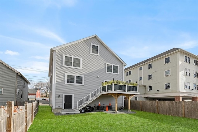 back of house with a lawn, stairs, and fence