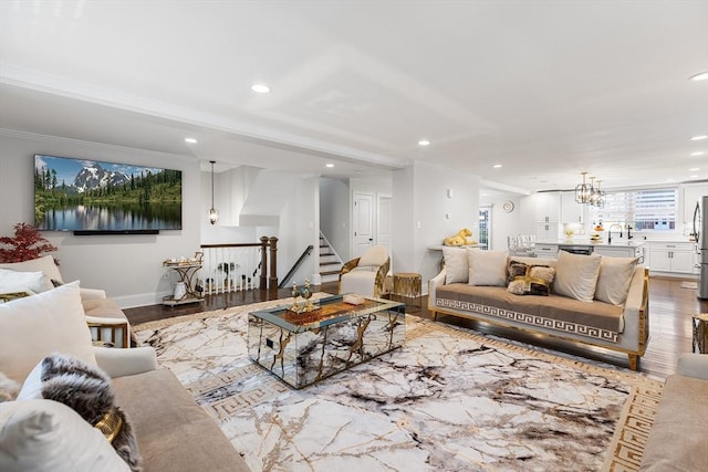 living area featuring crown molding, stairway, recessed lighting, wood finished floors, and a notable chandelier