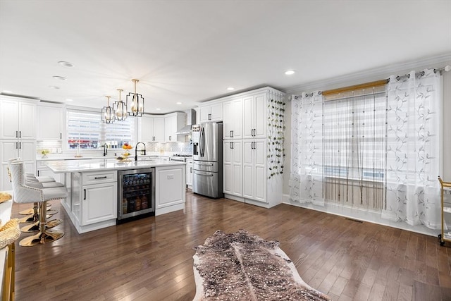 kitchen with wall chimney range hood, wine cooler, stainless steel appliances, white cabinetry, and dark wood-style flooring