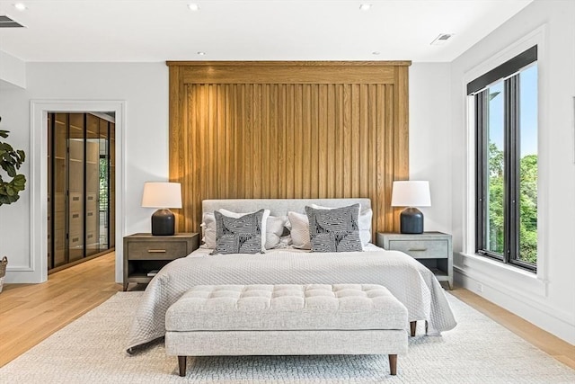 bedroom with light wood-style floors, visible vents, and baseboards