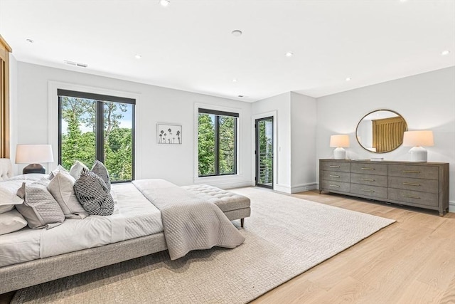 bedroom featuring light wood-type flooring, multiple windows, visible vents, and baseboards