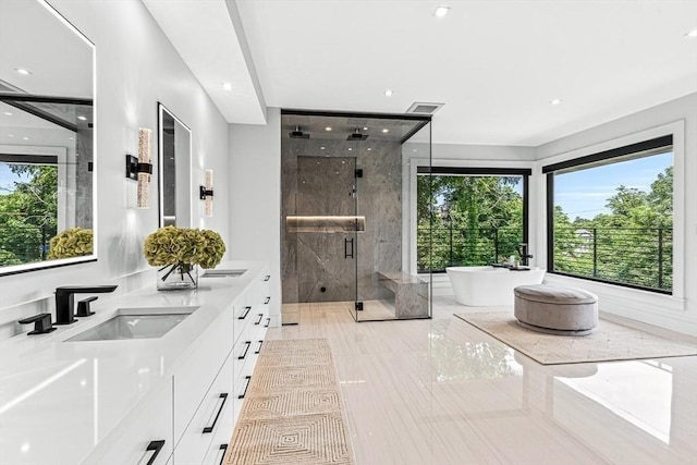 full bathroom featuring double vanity, a stall shower, visible vents, a soaking tub, and a sink