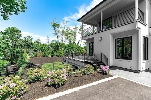 view of yard featuring a patio area, fence, and a balcony