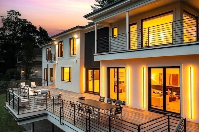 back of property featuring a balcony and stucco siding