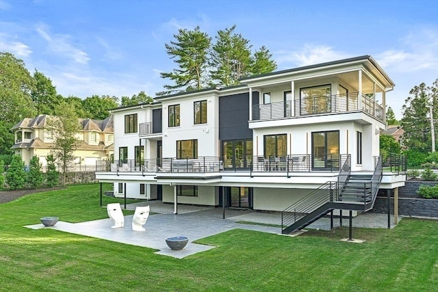 back of property with a lawn, a patio, a balcony, stairs, and stucco siding