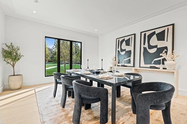 dining room featuring light wood-type flooring, crown molding, baseboards, and recessed lighting