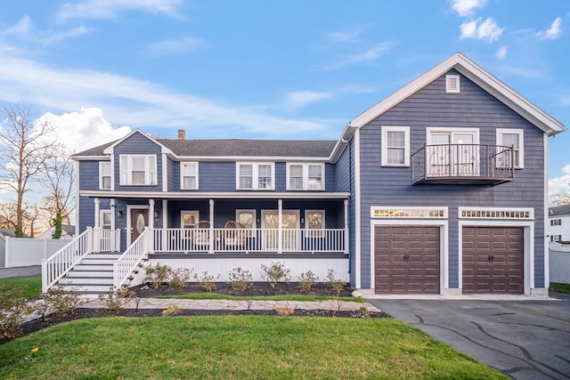 view of front of home featuring a front lawn, a porch, a garage, and a balcony