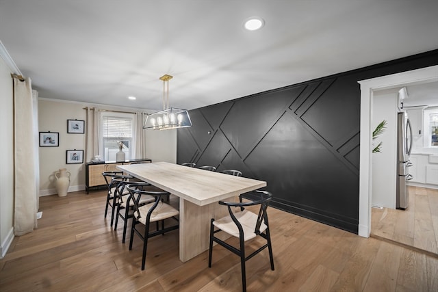 dining room featuring crown molding and light wood-type flooring