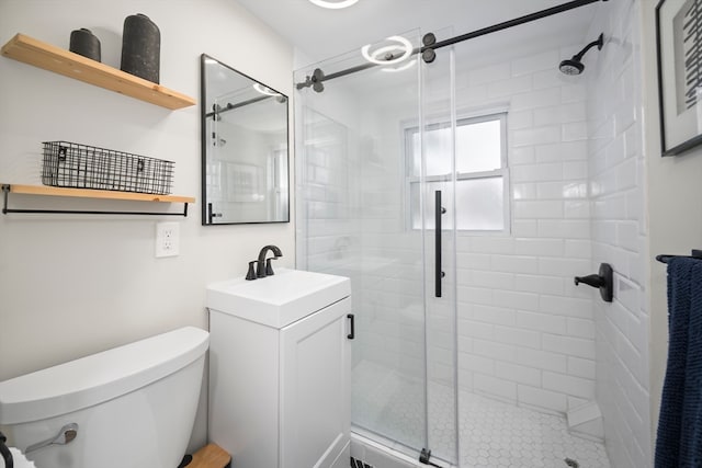 bathroom with vanity, toilet, and a shower with door