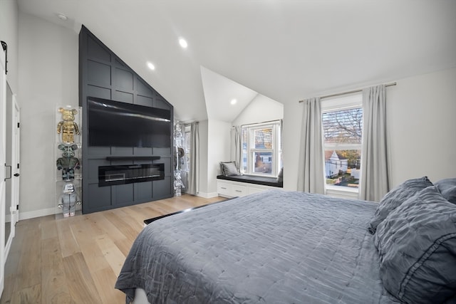 bedroom featuring light hardwood / wood-style floors and lofted ceiling