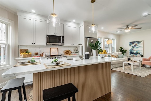 kitchen with visible vents, dark wood-style floors, appliances with stainless steel finishes, open floor plan, and backsplash