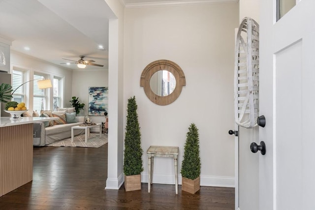 hallway with ornamental molding, dark wood finished floors, and baseboards