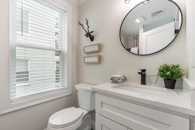 half bathroom with a healthy amount of sunlight, visible vents, toilet, and vanity