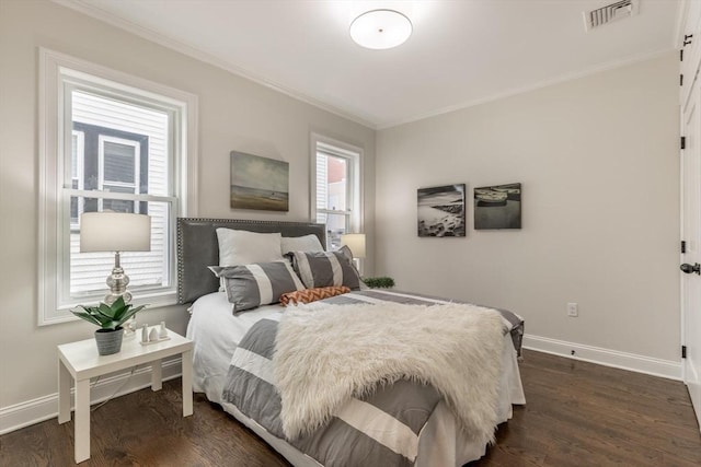 bedroom with ornamental molding, visible vents, dark wood finished floors, and baseboards