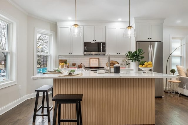 kitchen with baseboards, appliances with stainless steel finishes, decorative backsplash, and dark wood-type flooring