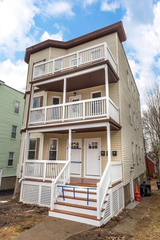 multi unit property featuring a balcony and covered porch