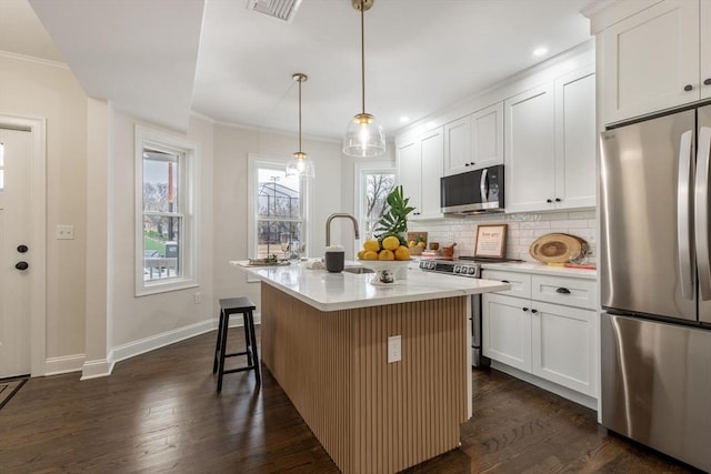 kitchen with dark wood-style floors, stainless steel appliances, tasteful backsplash, and visible vents