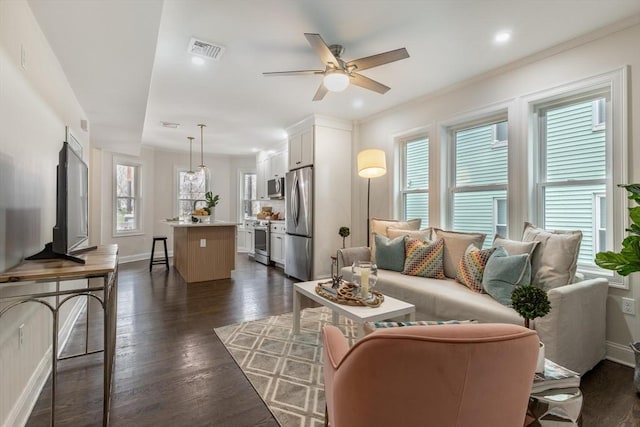 living room featuring a ceiling fan, dark wood finished floors, visible vents, and baseboards