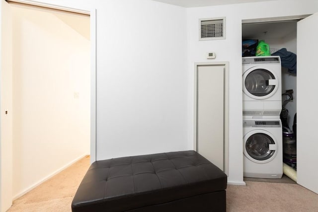 laundry room with stacked washer / dryer and light carpet