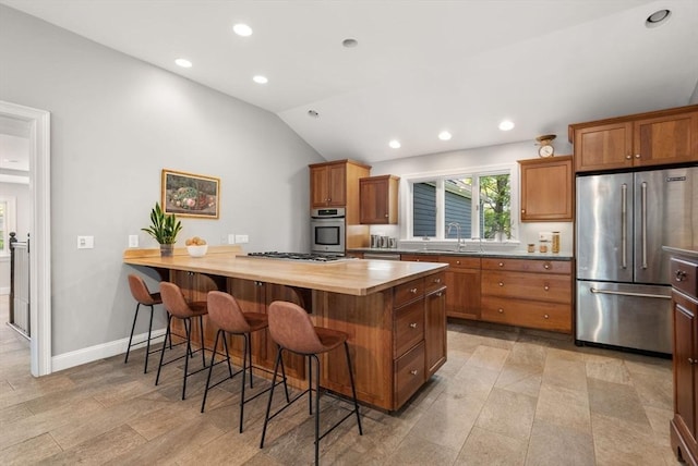 56 Arrowhead Rd, Weston, MA 02493 - kitchen with stainless steel appliances, a sink, a kitchen bar, wooden counters, and a peninsula