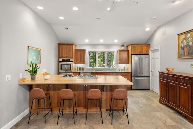 56 Arrowhead Rd, Weston, MA 02493 - kitchen featuring stainless steel appliances, lofted ceiling, a breakfast bar area, a sink, and a peninsula