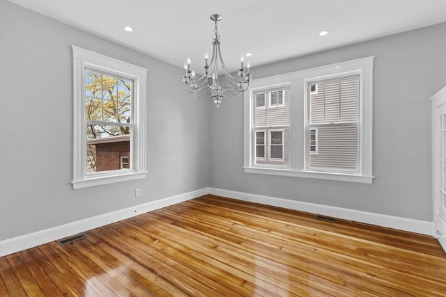 unfurnished dining area with light wood-style floors, visible vents, baseboards, an inviting chandelier, and recessed lighting